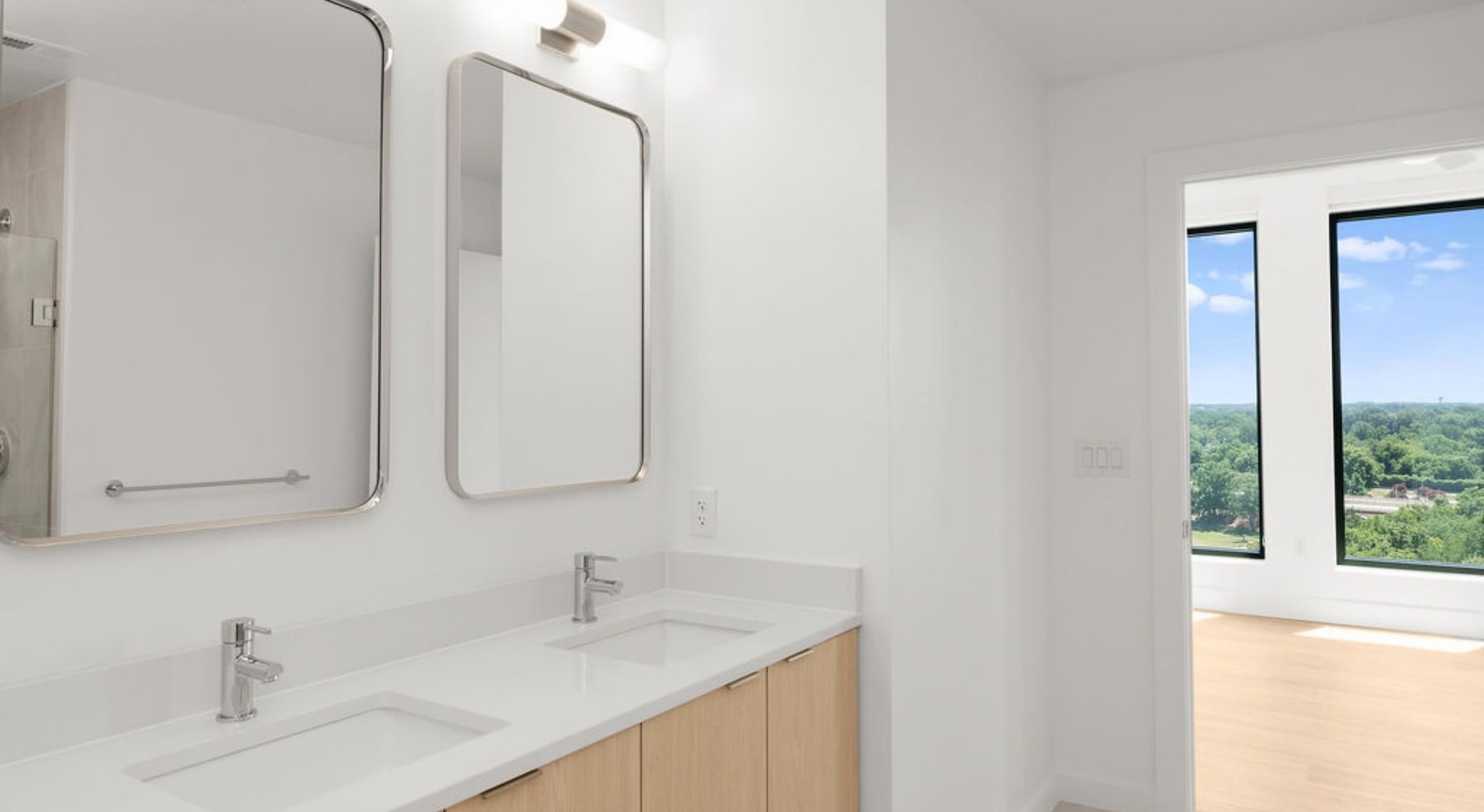 bathroom with two sinks and mirrors and white countertops