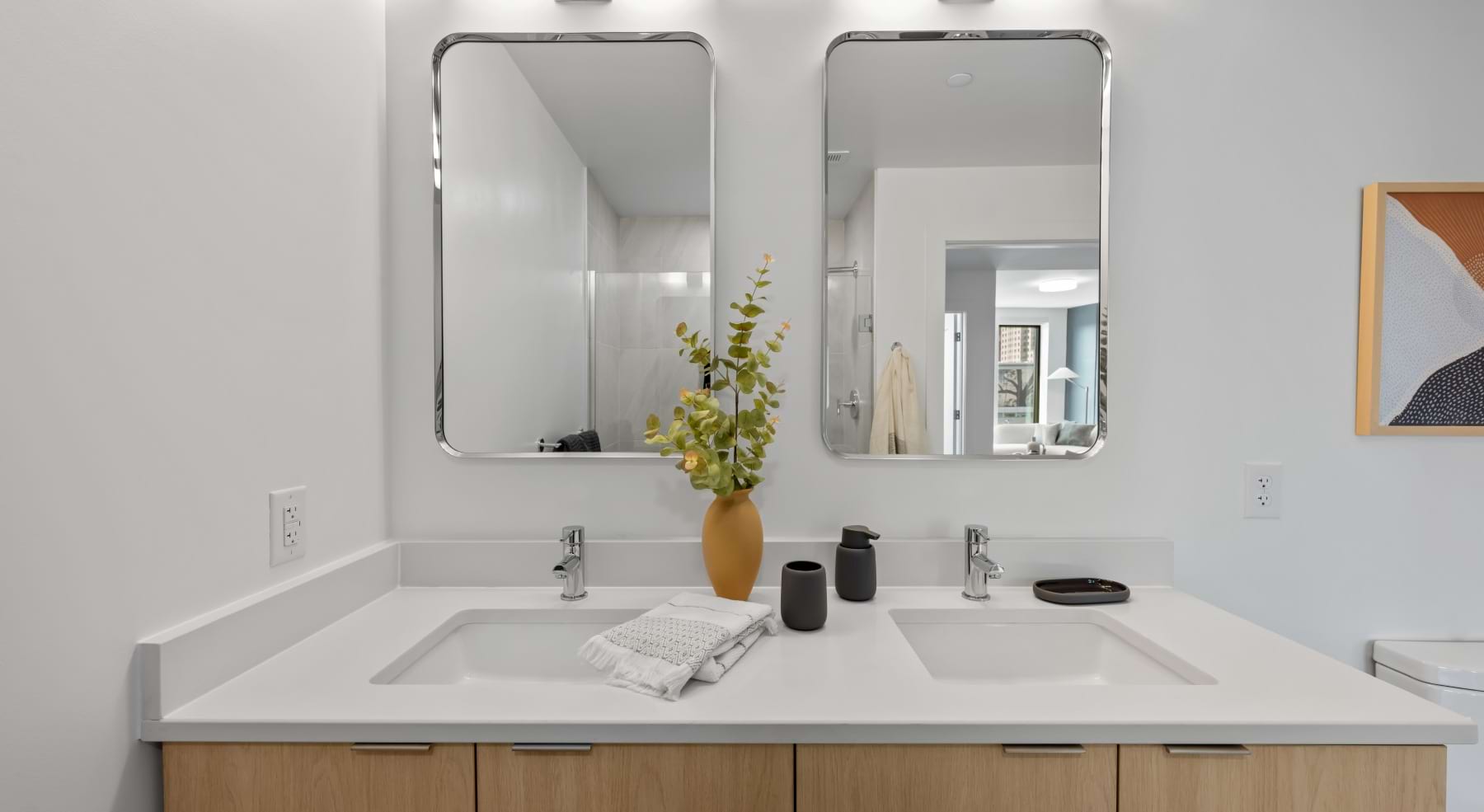 bathroom with two sinks and mirrors and white countertops