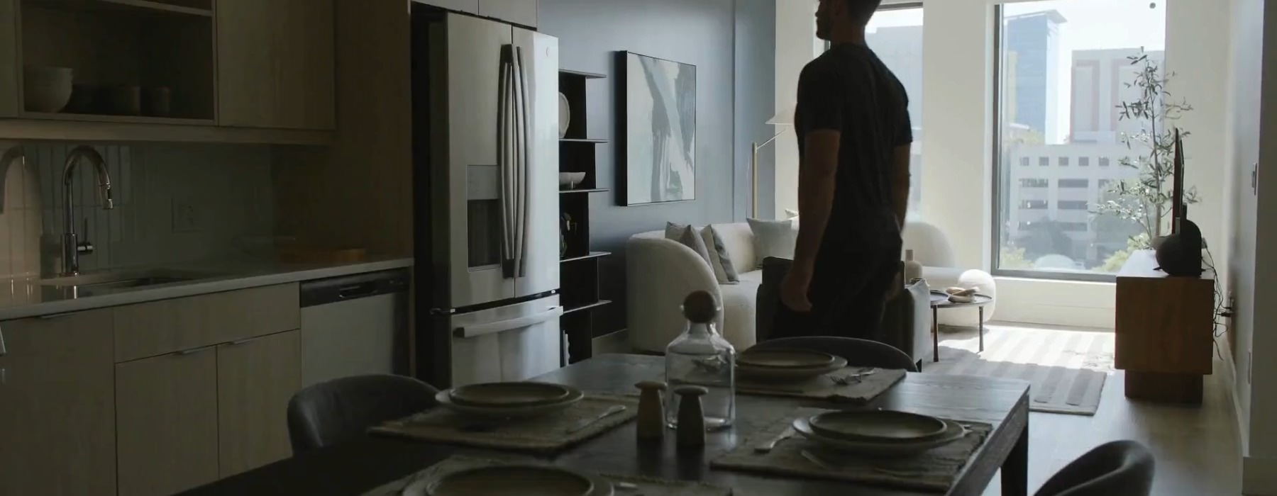a person walking through an apartment with large windows